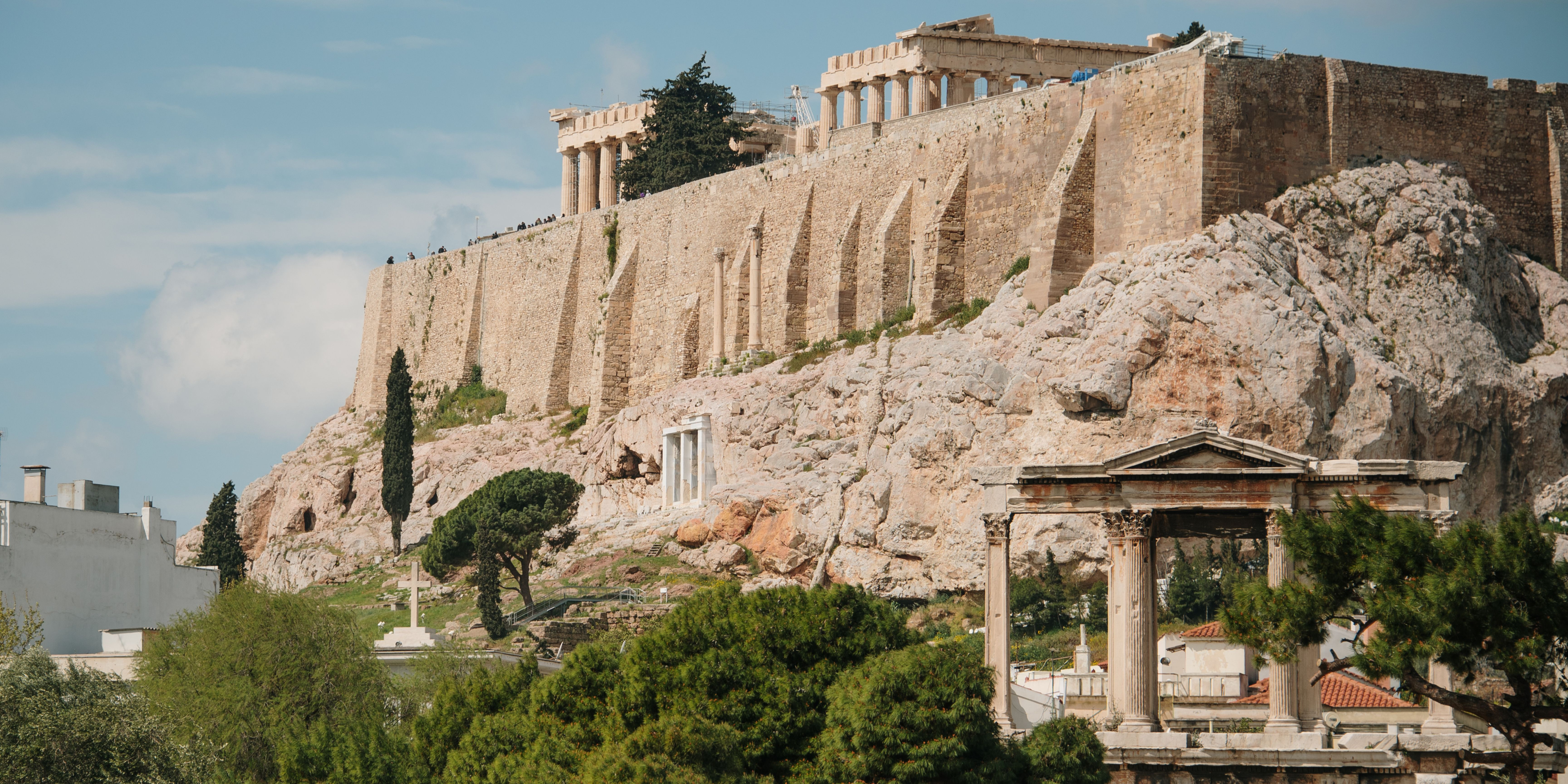 A view of the Acropolis in Athens, showcasing ancient structures and surrounding greenery.